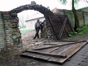 Zaniedbany PGR Cichowo. Tadeusz Popiel chce ściągnąć tu turystów budując kolejkę wąskotorową. Godz. 13.27 - właśnie zakończono wytyczanie szlaku kolejki.- Pod tą bramą pojedzie na podwórze - mówi Popiel. 