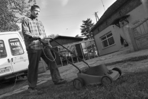 Stare Bojanowo - godzina 19:06 Pan Krzysztof Piechowiak kosi trawnik przy kwiaciarni, której jest właścicielem.