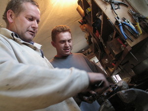 Bronikowo, warsztat w garażu. Jan Frąckowiak  i Roman Frąckowiak przy naprawie pompy podnośnika. Doglądać postępu prac przyszedł Antoni Frąckowiak. Głowa rodziny. Godzina 19.55-20.00.