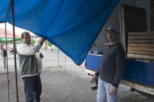 Czempiń, targ, godz. 13:04. Ojciec i syn Pilarscy składają plandekę stoiska na targu na rynku.