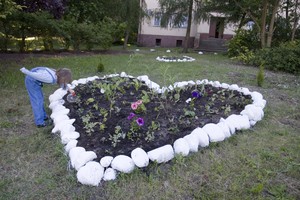 Zadory 4, Wnuczka pani Ewy Komin Weronika podlewa właśnie posadzone kwiatki w sercu z kamieni, które ułożyła jej mama Teresa. Zamieszkały tutaj dopiero miesiąc temu przeprowadzając się z Poznania. Dotychczas całe otoczenie było zarośnięte. Nowi gospodarze, nowe porządki.