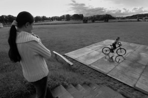 Stare Bojanowo, starsza siostra przygląda się bratu, który na boisku testuje swój ,,komunijny’’ rower.