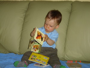 Fot. Adam M. Nowak. Zdjęcie przedstawia mojego 14-miesięcznego wnuka Alanka Szmatułę przeglądającego książeczki z obrazkami. Wykonałem je w mieszkaniu jego dziadków, w Kościanie na os. Konstytucji 3 Maja.