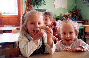 Fot. Emilia Chrzanowska. . Zdjęcie przedstawia 2,5 letnią Alicję Chrzanowską (pierwsza z lewej), córkę mojego brata, kończącą smaczne śniadanie w towarzystwie pozującej do zdjęcia koleżanki z grupy ,,Misiów’’. Zdjęcie wykonałam 06.06.06. r. o godz. 8,50 w sali ,,Misiów’’ Samorządowego Przedszkola nr 2 w Kościanie.