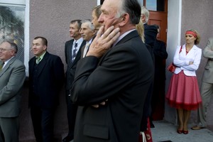 Panowie obserwują zmagania żon z obiektywem. 