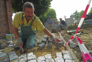 Lubiń - brygada z Poznania wykłada kostką brukową alejki na miejscowym cmentarzu 