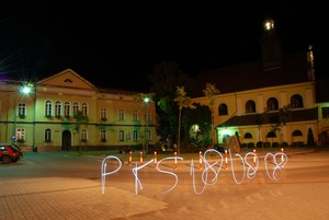 08.08.08 kilka minut po godzinie dwunastej w nocy. Plac Niezłomnych w Kościanie, zdjęcie wykonane od strony ulicy Sądowej. Przedstawiony jest Sąd rejonowy oraz kościół pod  wezwaniem Pana Jezusa. Długi czas naświetlania, silne punktowe źródło światła oraz zwinne ręce pozwoliły na wykonanie napisu który charakteryzuje tematykę projektu.   Fot. Krzysztof Szydłowski