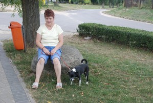 Autor: Krzysztof  Ostrowski.  Żona Teodozja odpoczywa na kamieniu przed barem „U Jankiela” w Cichowie