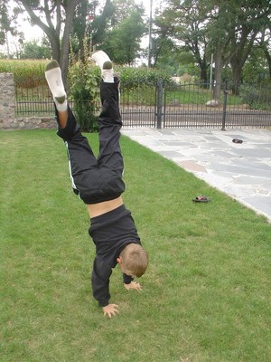 Autor: Justyna Ostrowska. 8-letni syn Szymon pokazuje swoje gimnastyczne umiejętności w Cichowie na działce.