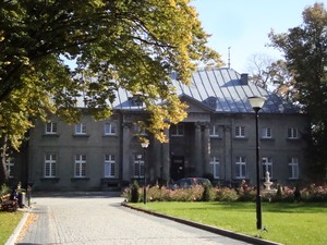 Leszek Żurczak – Pałac w Jarogniewicach. Zdjęcie przedstawia pałac z XVII wieku należący przed laty do rodziny Żółtowskich, obecnie mieści się w nim Dom Pomocy Społecznej dla osób niepełnosprawnych fizycznie, ze szczególnym uwzględnieniem osób niewidomych, ociemniałych i z resztką wzroku. Na ławce przed budynkiem siedzi mieszkaniec Domu Krzysztof Młynek.