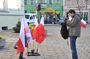 Fot. Dariusz Borowski. Mariusz Drabik wykonuje pamiątkowe zdjęcie córce Oli wśród flag narodowych na Rynku w Kościanie przed uroczystościami z okazji Święta Niepodległości.