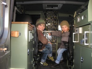 Autor: Lidia Karmelska.  Kościan, Rynek. Bracia Borys i Aleksander Karmelscy zwiedzają wnętrze wojskowego auta podczas obchodów Święta Niepodległości.