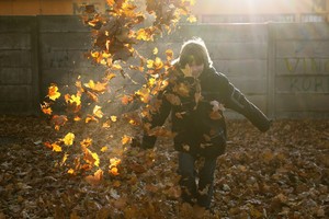 Julia Tycner - zdjęcie przedstawia mojego brata Konrada podczas zabawy w jesiennych liściach na terenie parku KOK