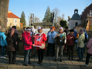 Grupa studentów z Sekcji Turystycznej KU TW na drodze przed kościołem w Rąbiniu w trakcie kosztowania rogali świętomarcińskich.