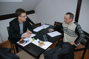 Autor - Mateusz Nejranowski. Biuro Rady Miejskiej Krzywinia. Bartosz Kobus, asystent burmistrza Krzywinia dyskutuje o budżecie gminy Krzywiń na rok 2013 z Przewodniczącym Komisji Gospodarczej Rady Miejskiej Panem Andrzejem Kaczmarkiem.