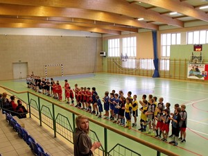 Autorka - Sandra Głowicka. Rozpoczęcie XIV Gwiazdkowego Turnieju o Puchar Starosty Kościańskiego w Piłce Nożnej Halowej Szkół Podstawowych w Starych Oborzyskach. Na pierwszym planie - Wiktoria Kasińska. Zdjęcie wykonano w ramach działalności Koła FOTO-WIDEO z Gimnazjum im. Jana Pawła II w Starych Oborzyskach.