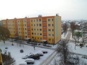Fot. Emilia Chrzanowska. Blok w nowej elewacji na os. Jagiellońskim w Kościanie i plac zabaw przykryty śniegiem. Zdjęcie wykonałam z okna na czwartym piętrze os. Jagiellońskie 10/10.