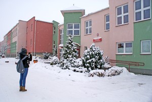 Autor - Wojciech Dyrcz. Przed wejściem głównym do gimnazjum - Sandra Głowicka podczas fotografowania do Projektu PKS121212. Zdjęcie wykonano w ramach działalności Koła FOTO-WIDEO z Gimnazjum im. Jana Pawła II w Starych Oborzyskach